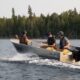 three men heading out to a fishing spot in a boat rental they booked in Kawartha Lakes