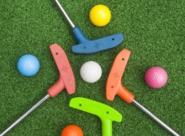 putters and golf balls on the green at a mini-golf location in the Kawartha Lakes