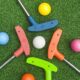 putters and golf balls on the green at a mini-golf location in the Kawartha Lakes